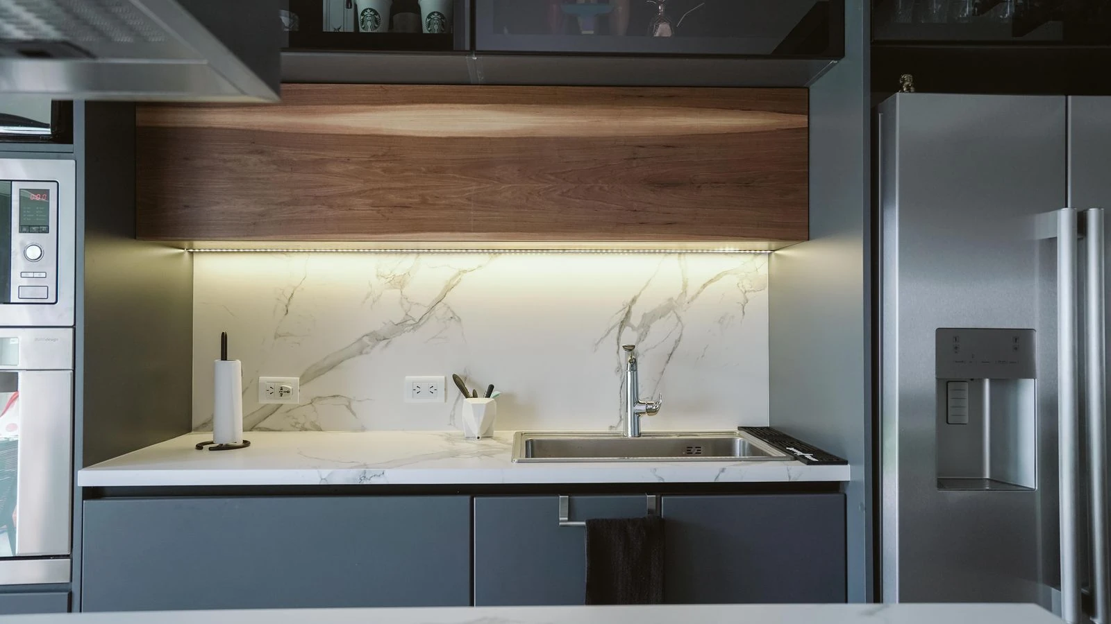 Fotografía de una cocina real con muebles grises y cubierta clara